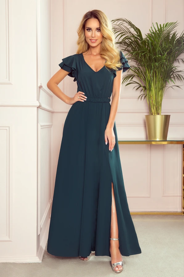 Rochia lungă, elegantă, de culoare verde închis, are un design cu mâneci scurte și volane delicate. Materialul fluid și despicătura laterală adaugă un plus de rafinament și feminitate.
