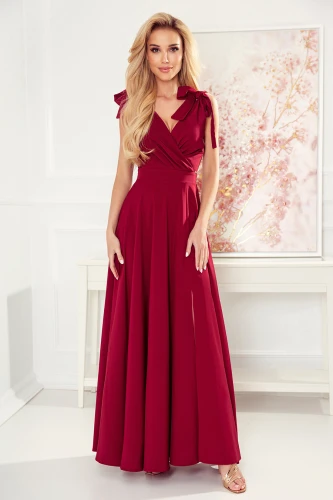 Rochia lungă de seară, de culoare roșu intens, are un design elegant cu bretele late și funde decorative pe umeri. Materialul fluid și croiala în formă de A oferă un aspect sofisticat și rafinat.}