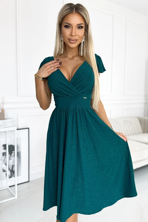 Rochia elegantă Matilde are o croială feminină cu decolteu în V și mâneci scurte, perfectă pentru ocazii speciale. Materialul verde smarald adaugă un plus de rafinament și strălucire subtilă ținutei.