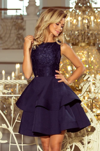 Rochia elegantă, de culoare albastru închis, are un design fără mâneci și un corset din dantelă delicată. Fusta în stil cloș, cu straturi suprapuse, adaugă un aer sofisticat și feminin.}