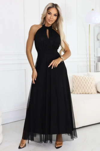 Model în rochie neagră, lungă din tul cu decolteu halter și mic decupaj tip lacrimă, cu talie definită și partea de jos vaporoasă, evazată.}