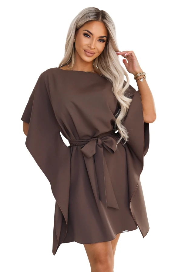 Model purtând rochia SOFIA de la Numoco în nuanța maro mocha. Rochia ajunge chiar deasupra genunchilor, are decolteu barcă, mâneci late de tip fluture și o curea legată la talie în fundă.