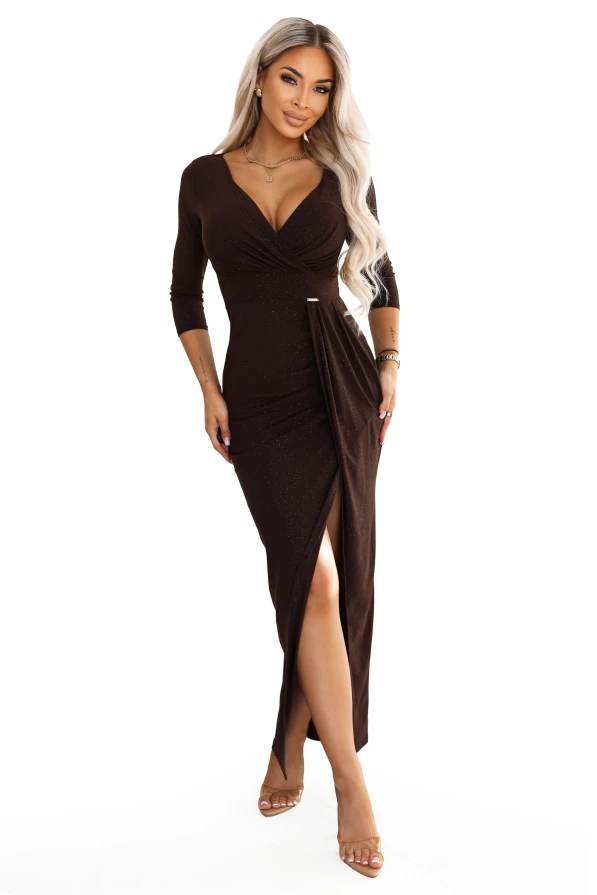 Model purtând o rochie maxi ciocolatie Numoco, cu efect de sclipici, decolteu petrecut, mâneci 3/4, drapaj la talie și despicătură în față.