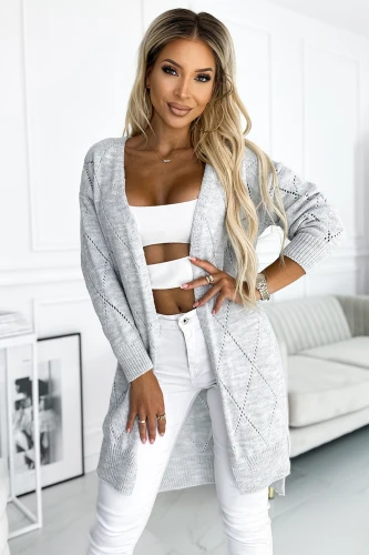 Modelul poartă un cardigan gri deschis, cu un design tricotat și detalii geometrice subtile. Cardiganul este lejer și elegant, perfect pentru un look casual și confortabil.}