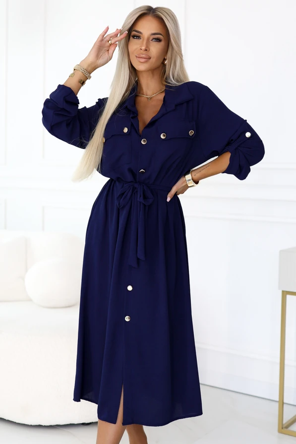 Modelka w granatowej szmizjerce z paskiem i złotymi guzikami – elegancka sukienka koszulowa marki Numoco Basic, idealna na co dzień i do pracy.