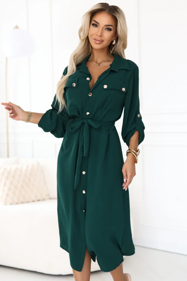 Modelka prezentuje elegancką zieloną sukienkę koszulową midi z możliwością podpięcia rękawów, idealną do pracy i na co dzień.