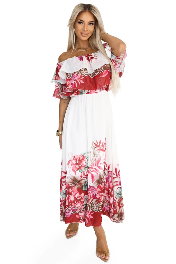 Modelka z gracją prezentuje letnią sukienkę maxi hiszpankę z falbaną i kwiatowym wzorem w odcieniach czerwieni i różu. Jej swobodna poza i uśmiech podkreślają romantyczny, kobiecy charakter tej stylizacji od Numoco Basic.